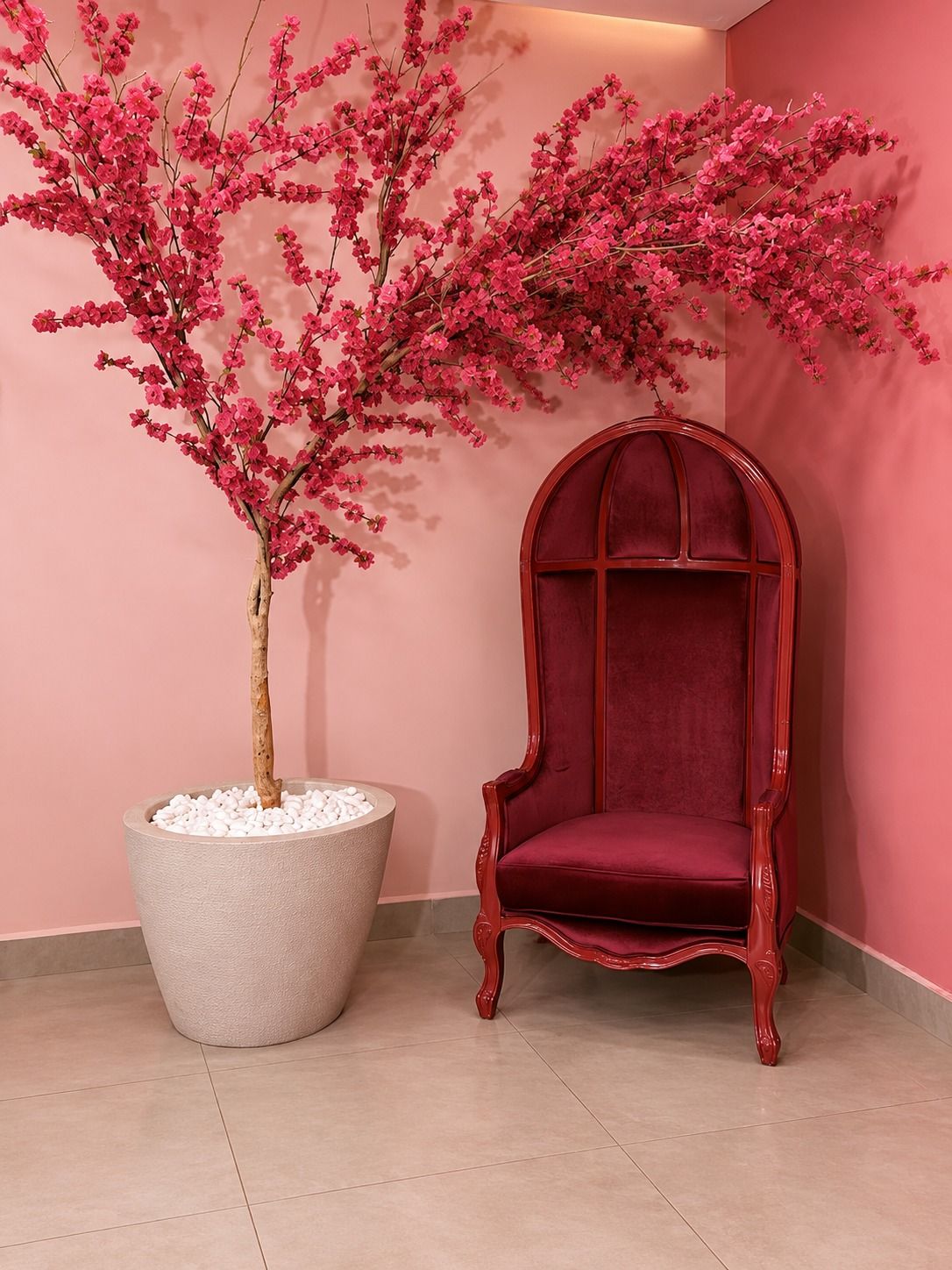 Poltrona vermelha e árvore de flores rosa na área de espera
