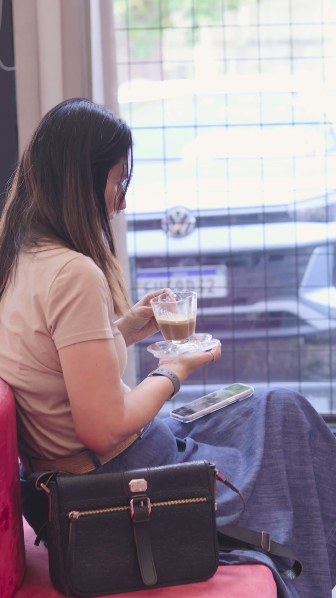 Cliente tomando café sentada na área de espera da clínica