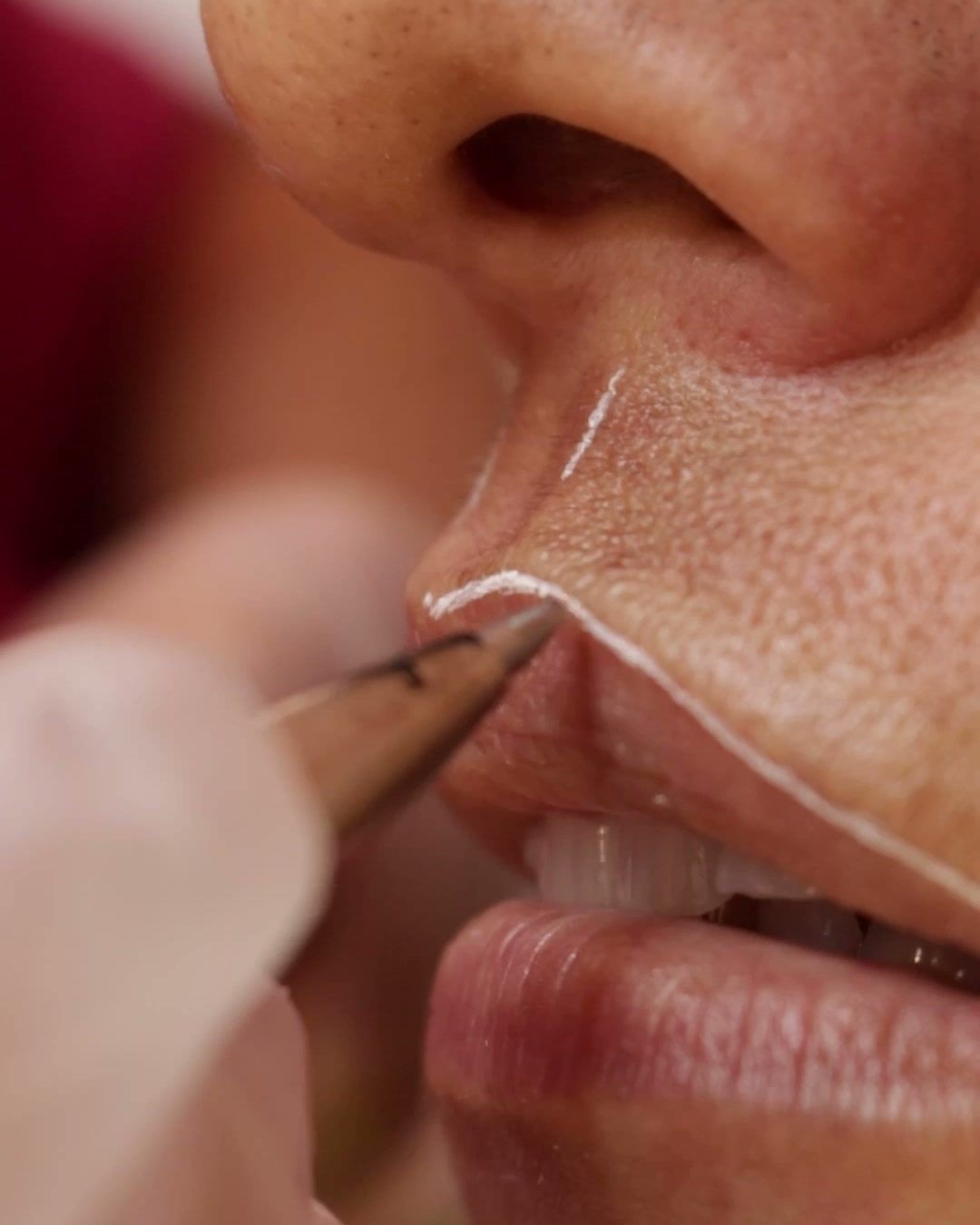 Profissional desenhando o contorno dos lábios antes da micropigmentação labial